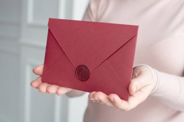 Close-up davetiye kartı zarf ellerini, önden görünüm tutan kadın