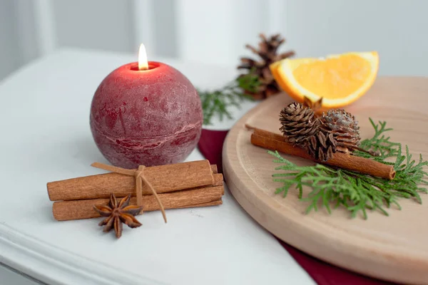 Candle decorated with cinnamon sticks. Christmas table decoration