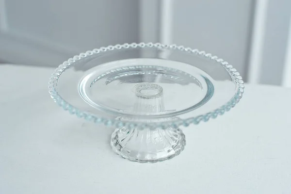ラウンド ガラス スタンド ケーキやデザート白い背景に白いテーブルの上のガラス球で飾られています — ストック写真