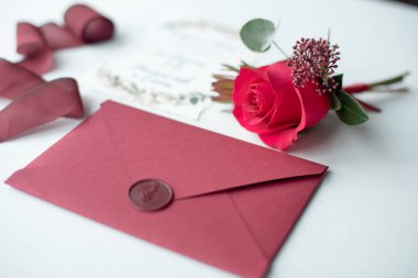 Beyaz masa örtüsü bir çiçek düzenleme ile dekore edilmiş bir mektup olarak davet düğün