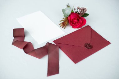 Beyaz masa örtüsü bir çiçek düzenleme ile dekore edilmiş bir mektup olarak davet düğün