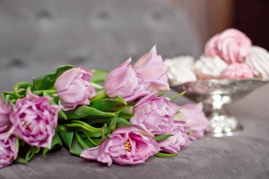 Vintage bir metal vazo yanında lavanta mor laleler zarif bir iç, kutlama kavramı içinde ev yapımı krema dolu.