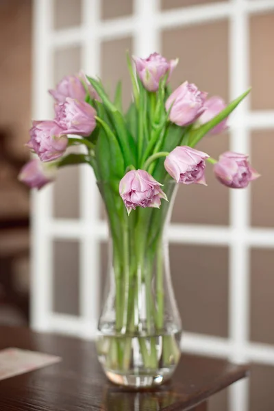 Ramo de flores de tulipán rosa fresco en el estante frente a la pared. Ver con espacio de copia . —  Fotos de Stock