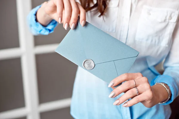 招待状、商品やサービスのカードに青い長方形のギフト封筒をもつ少女のクローズ アップ. — ストック写真
