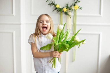 Beyaz bir gömlek, oldukça küçük bir kız portresi, o şaşırır ve Lale buketi tutarak..