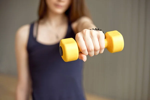 Fitness woman with barbells on grey background