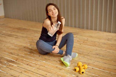 Bir egzersiz bir atlet spor giyim, spor salonunda içme suyu bir şişe bir mola sırasında tutar sonra kadın atlet içme suyu ile bir mola alır.