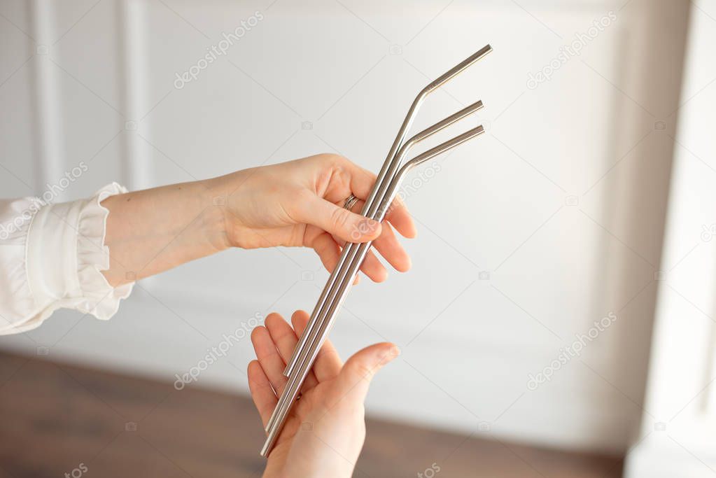 Girl is holding stainless steel straws to reduce the amount of plastic waste in the environment