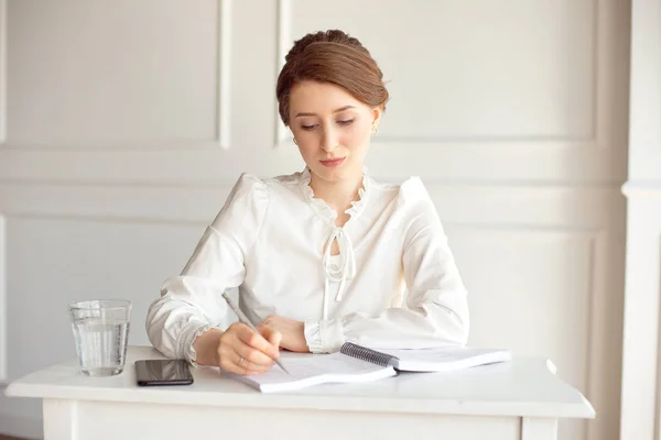 Jonge vrouw ondertekent belangrijke documenten zittend aan haar Bureau in een kantoor. Pretty Kaukasische vrouwelijke werken in een kantoor aan huis — Stockfoto