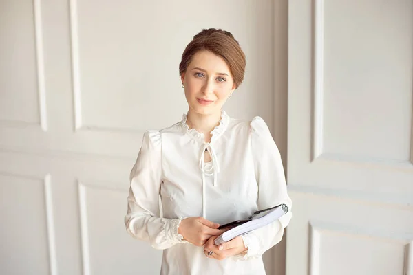Foto mulher de negócios vestindo terno, olhando smartphone e segurando documentos em mãos — Fotografia de Stock