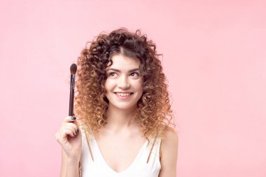 Güzellik salonunda çalışırken makyaj fırçası ile oturan neşeli mutlu kadın