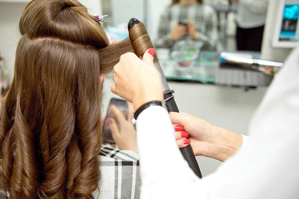 Peluquería mujer haciendo peinado a chica rubia en salón de belleza . —  Fotos de Stock
