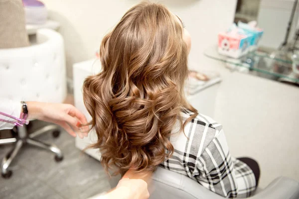 Peluquería mujer haciendo peinado a chica rubia en salón de belleza . —  Fotos de Stock