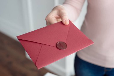 Kadın davet kartlarını elinde tutar. El zarfları yakın çekim