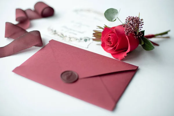Esküvői meghívó egy díszített levél-ra egy fehér terítő együtt egy virág elrendezése. — Stock Fotó