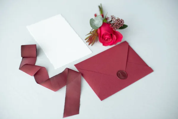 Invitación de boda como carta decorada sobre un mantel blanco con arreglo floral . — Foto de Stock