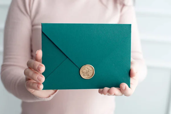 Close-up de mulher segurando envelope de cartão de convite nas mãos, vista frontal . — Fotografia de Stock