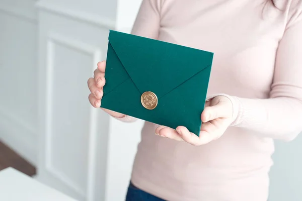 Närbild av kvinna som innehar inbjudningskort kuvert i händerna, framifrån. — Stockfoto