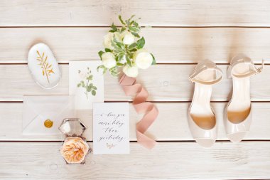 Bir kurdele, düğün davetiyesi, yüzük ve doku üzerinde gelin ayakkabıları ile Zarif düğün buketi.