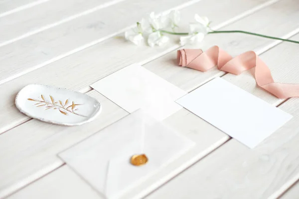 白い花の枝と白い木製のテーブルの上にスパやケア装飾されたレターカードのための結婚式の招待状の誕生日のギフト券. — ストック写真