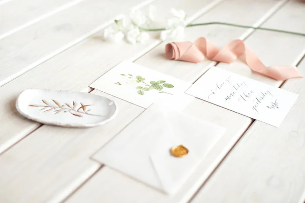 白い花の枝と白い木製のテーブルの上にスパやケア装飾されたレターカードのための結婚式の招待状の誕生日のギフト券. — ストック写真