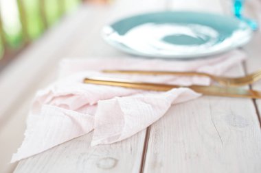 Misafirler için masa, mumlar ile dekore edilmiş, çatal ve tabak ile servis ve pembe gazlı bez peçete üzerinde bir masa örtüsü mavi plaka ve altın çatal ve bıçak ile kaplı