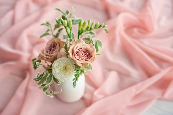 Magnifico bouquet di fiori diversi è una disposizione floreale in un vaso di ceramica bianca di forma rotonda. Apparecchiatura della tavola è lilla e pesca — Foto Stock