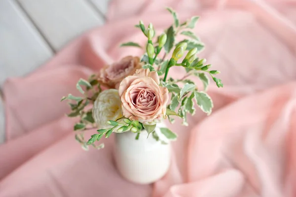 Magnifico bouquet di fiori diversi è una disposizione floreale in un vaso di ceramica bianca di forma rotonda. Apparecchiatura della tavola è lilla e pesca — Foto Stock