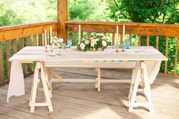 Украшенный стол на ужин на двоих, с ножом, вилкой, сыром, вином, бокалами для вина и цветами в медной вазе — стоковое фото