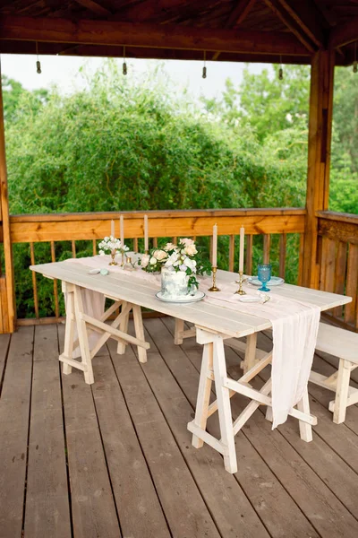 Tisch zum Abendessen für zwei Personen, mit Tellern Messer, Gabel, Käse, Wein, Weingläsern und Blumen in einer Kupfervase — Stockfoto