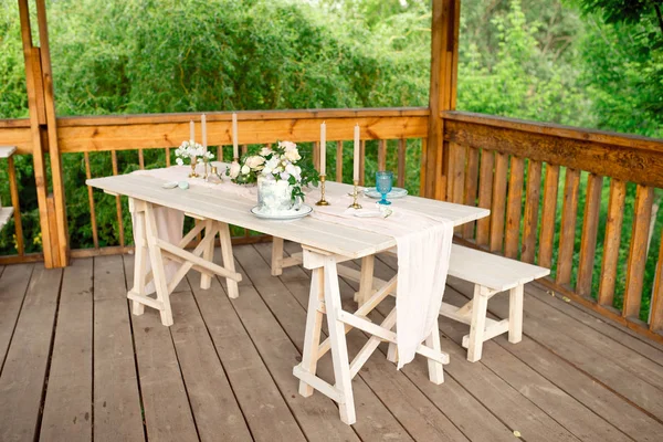 Mesa decorada para jantar para duas pessoas, com pratos faca, garfo, queijo, vinho, copos de vinho e flores em um vaso de cobre — Fotografia de Stock