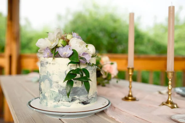 Mesa de decoración de bodas en el jardín, arreglo floral, en el estilo vintage en el exterior. Pastel de boda con flores. Mesa decorada con flores, servida para dos personas —  Fotos de Stock