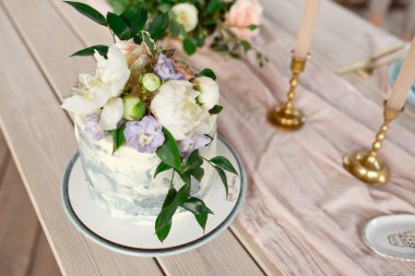 Bahçede düğün dekorasyon masası, çiçek aranjmanı, açık havada tarzı vintage. Çiçekli düğün pastası. Çiçeklerle süslenmiş masa, iki kişi için servis