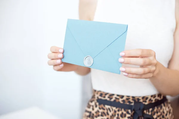 Close-up mulher com corpo magro segurando nas mãos o cartão de convite azul cor-de-rosa forma quadrada envelope cartão . — Fotografia de Stock