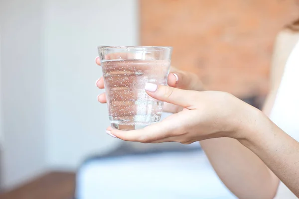 Manos femeninas sosteniendo un vaso de agua transparente. Un vaso de agua mineral limpia en las manos, bebida saludable . —  Fotos de Stock