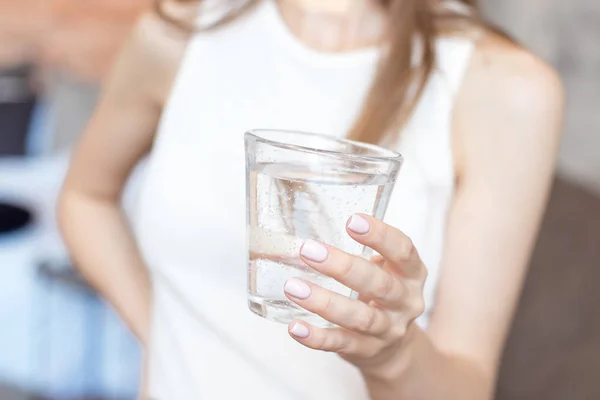 Close-up woman with slim body holding a glass of water, rear veaw. — Stock Photo, Image