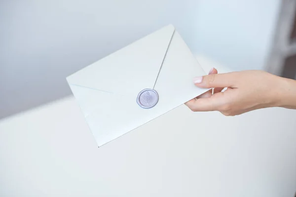 Close-up foto de mãos femininas com selo de cera com envelope de convite, certificado de presente, cartão postal, cartão de convite de casamento . — Fotografia de Stock
