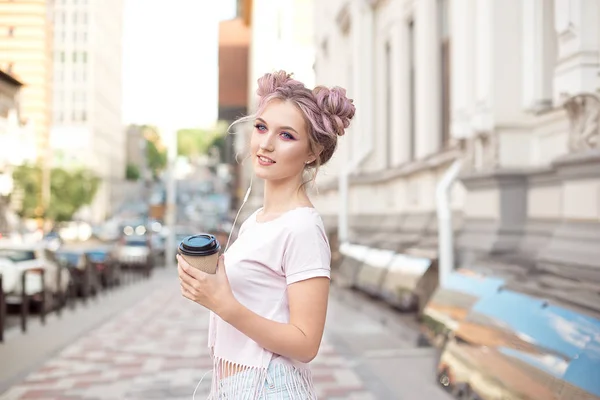 ピンクの髪の毛の髪型で笑顔の美しい女の子は、美しい晴れた日を楽しんでコーヒーのカップで通りを歩きます. — ストック写真