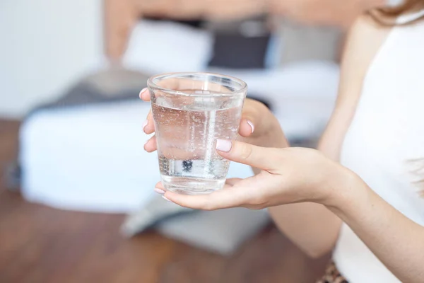 Manos femeninas sosteniendo un vaso de agua transparente. Un vaso de agua mineral limpia en las manos, bebida saludable . —  Fotos de Stock