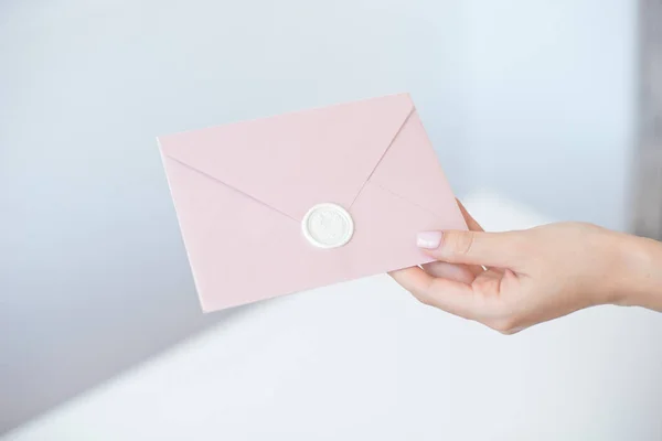 Close-up foto de mãos femininas segurando envelope convite com um selo de cera, um certificado de presente, um cartão postal, cartão de convite de casamento — Fotografia de Stock
