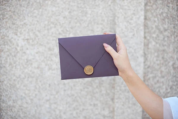 Ung flicka innehar post inbjudningskort i handen. Kuvert med vax tätning i hands Close-up. — Stockfoto
