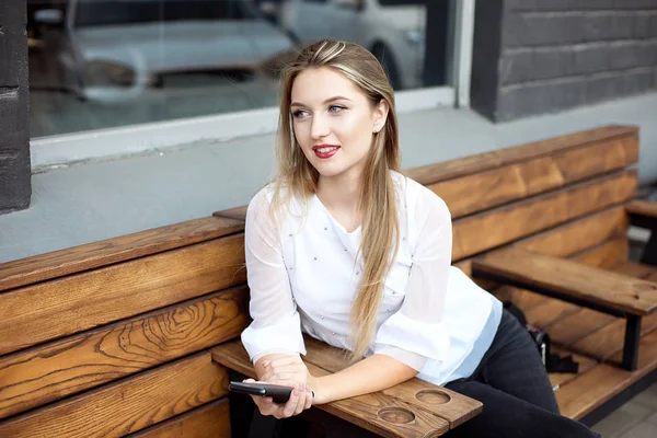 Bonita jovem empresária bonita no café usando celular e beber café sorrindo . — Fotografia de Stock