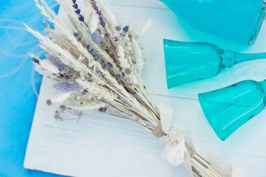 Mavi şampanya ve farklı peynirler, mevsimlik bir açık hava veya tatil partisi veya piknik için kavram ile tabak bir şişe ile ahşap beyaz piknik masası.