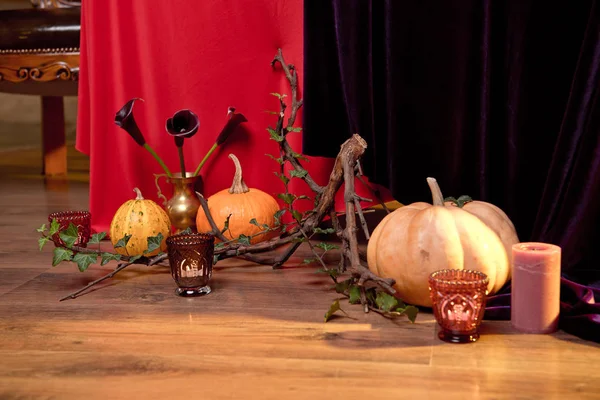 Ramo floral de otoño en un jarrón de cobre sobre un piso de madera decorado con calabazas para velas de Halloween. Establecimiento de mesa para las vacaciones . — Foto de Stock