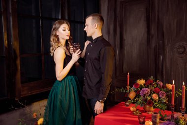 Cadılar Bayramı partisinde kokteyl içme vampirler gibi giyinmiş genç insanlar.