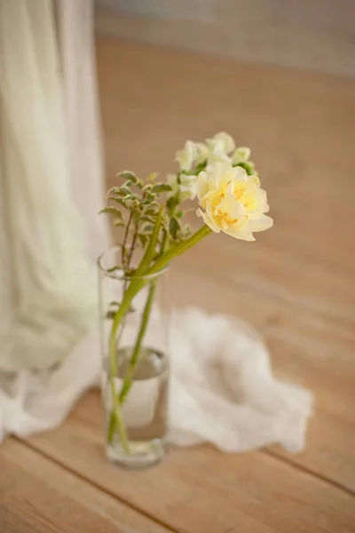屋内の木製の光床のガラスの花瓶に咲く白いピオニーチューリップマッティオラ支店の枝. — ストック写真