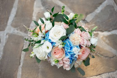 Muhteşem bir buket gül, ortanca, ozotamnusa, okaliptüs güzel bir beton yolda.