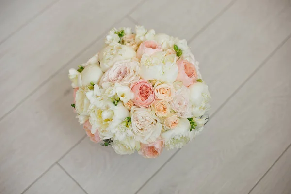 Bouquet da sposa sdraiato sul tappeto grigio durante la preparazione prima della celebrazione. Vista laterale di rosa decorativa, peonie fiori e foglie bouquet — Foto Stock