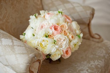 Güzel bej rengi pembe güller, pembe orkideler, kasımpatılar ve kahverengi kanepede karışık ve beyaz östomasyon çiçekleri.