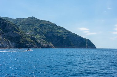 Avrupa, İtalya, Cinque Terre, Riomaggiore, arkasında dağ olan büyük bir su kütlesi.